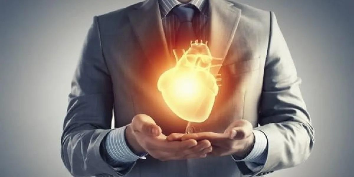 gros plan d'homme d'affaires détenant numérique coeur rougeoyant dans la paume