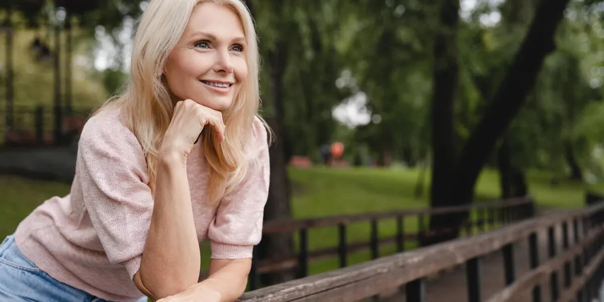 dreamy pensive caucasian mature blonde woman walking relaxing resting in city park forest spending free time in woods