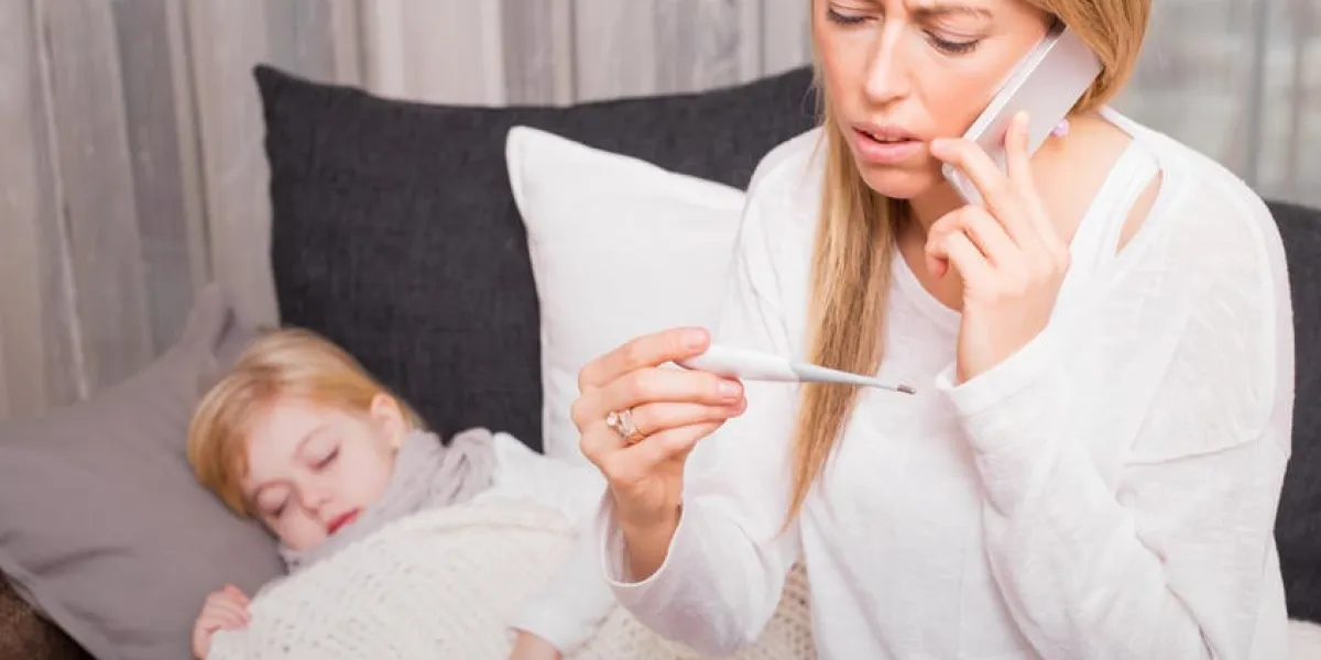 mère appelant médecin et regardant thermomètre