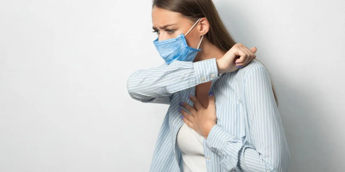 coronavirus respiratory hygiene sick girl coughing into elbow wearing protective medical mask having covid-19 pneumonia standing over white background copyspace