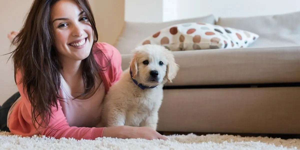woman lying on floor with a puppy