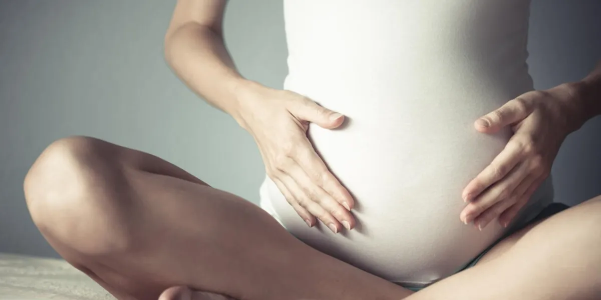 image de femme enceinte touchant son ventre avec les mains