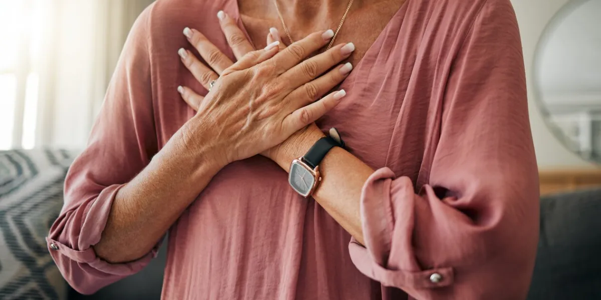 senior woman, hands or chest pain in heart attack, anxiety or panic in house or home living room zoom, stroke or cardiovascular emergency for sick retirement elderly or stress person in medical risk