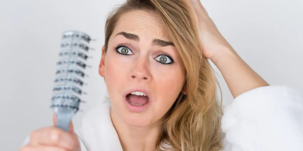 femme inquiète souffrant de hairloss regardant peigne