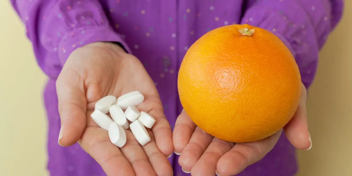 woman hand with pills medicine tablets and grapefruit
