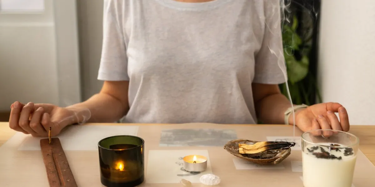 unrecognizable female sitting in pose and finding peace at aromatherapy burning aromatic sandalwood sticks at home meditation and relaxation mindfulness concentration energy practice