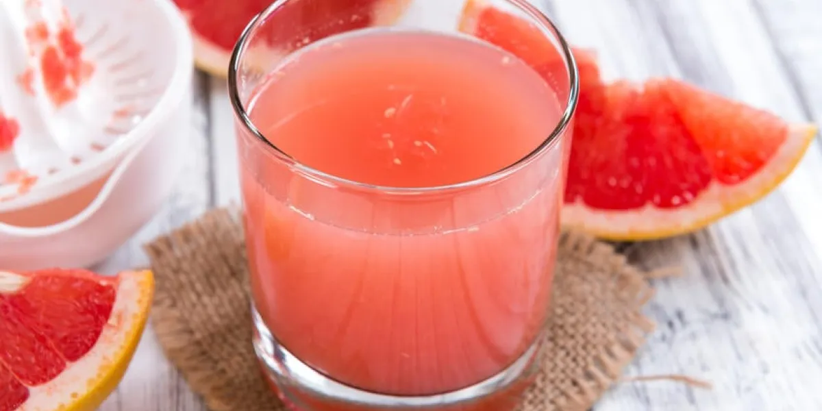 jus de pamplemousse fraîchement pressé (gros plan) sur fond en bois vintage