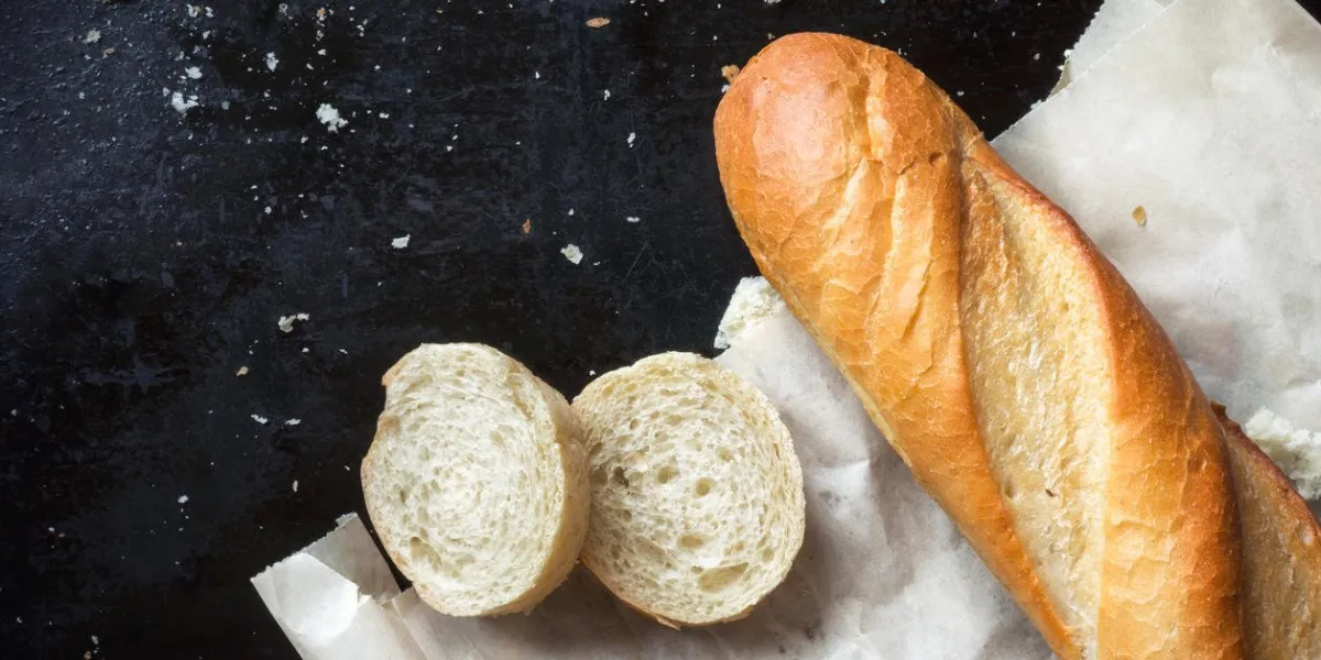 baguette française tranchée avec des miettes sur papier