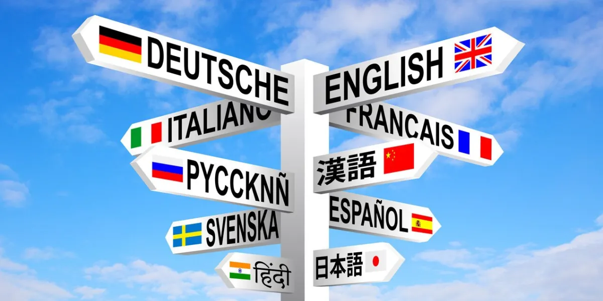 multilingual languages and flags sign post against blue sky