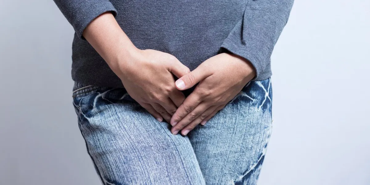 femme avec les mains tenant son entrejambe isolé sur fond blanc