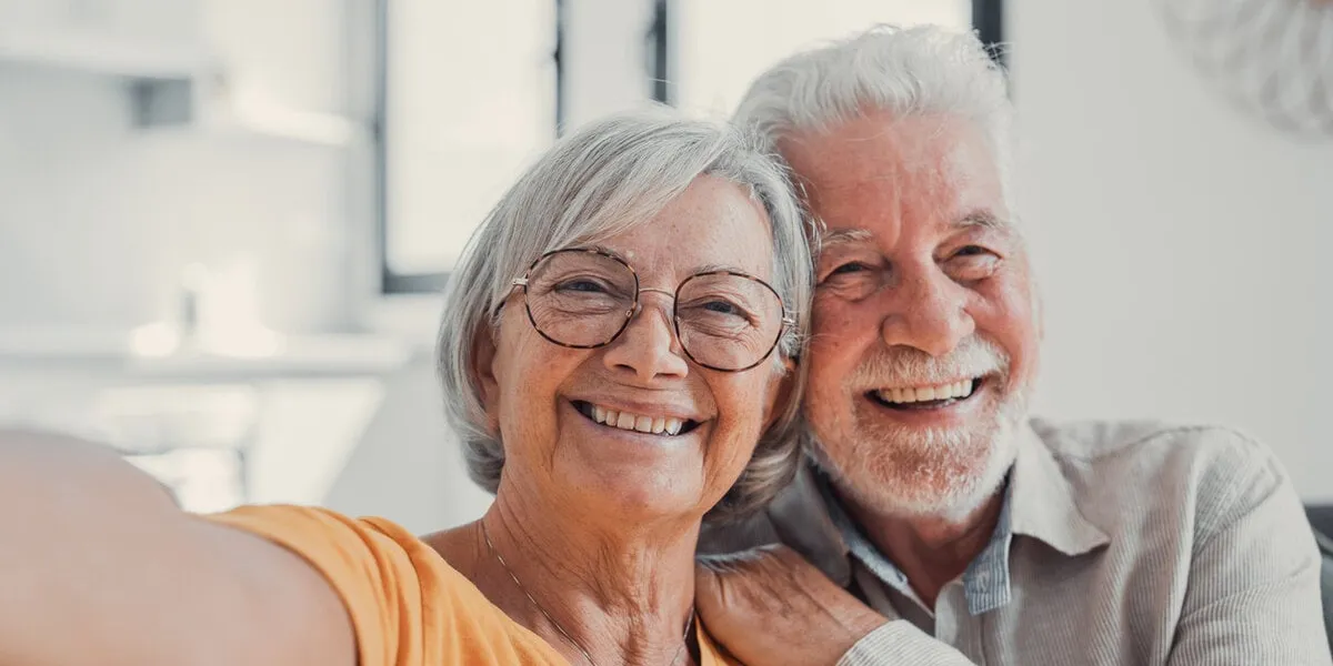 head shot portrait happy senior couple taking selfie, having fun with phone cam, smiling aged wife and husband hugging, looking at camera, posing for photo, aged man vlogger recording video