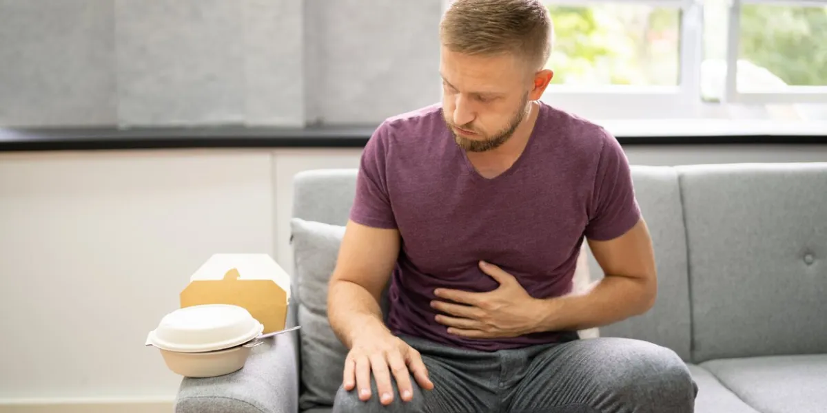 unhealthy fastfood stomach heartburn person after eating food