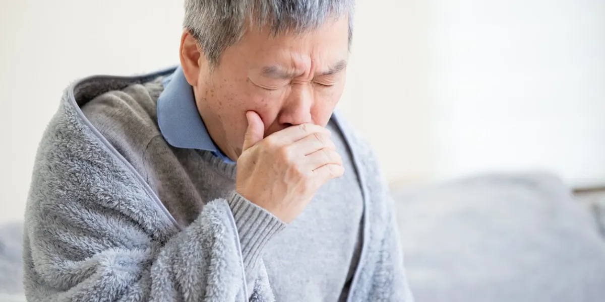 asian eldely sick man has a cold and cough at home