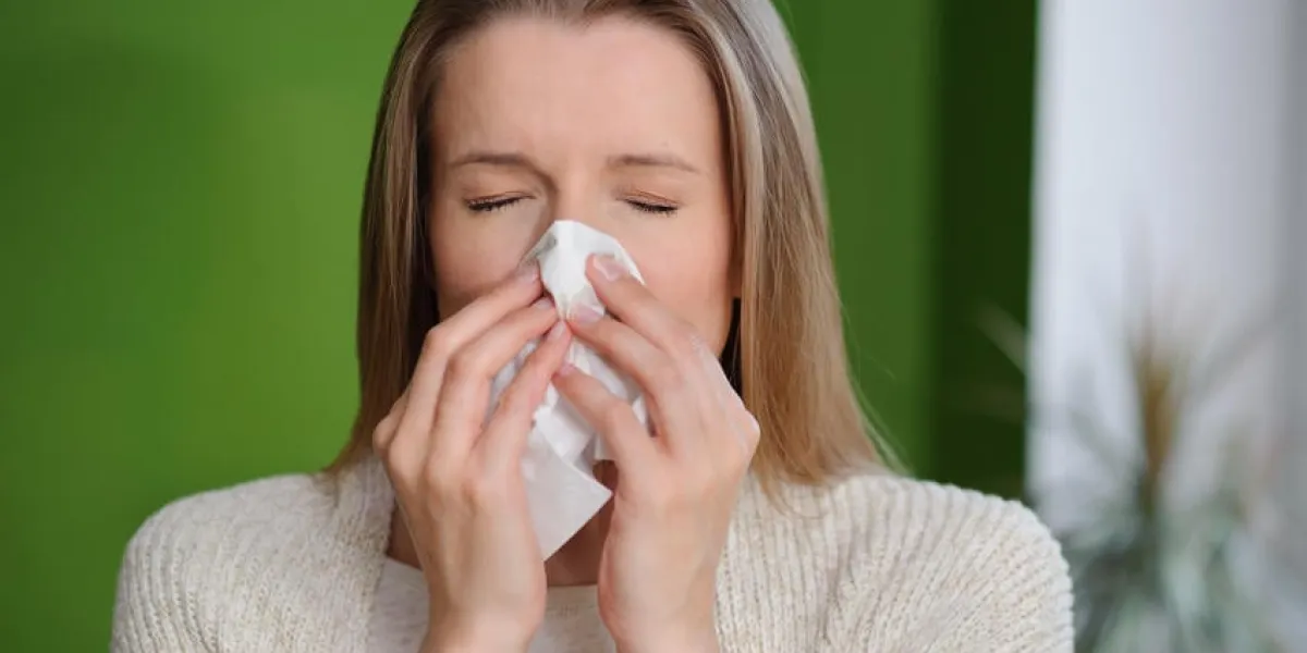 femme soufflant nez qui coule - maladie de la grippe froide - fond vert