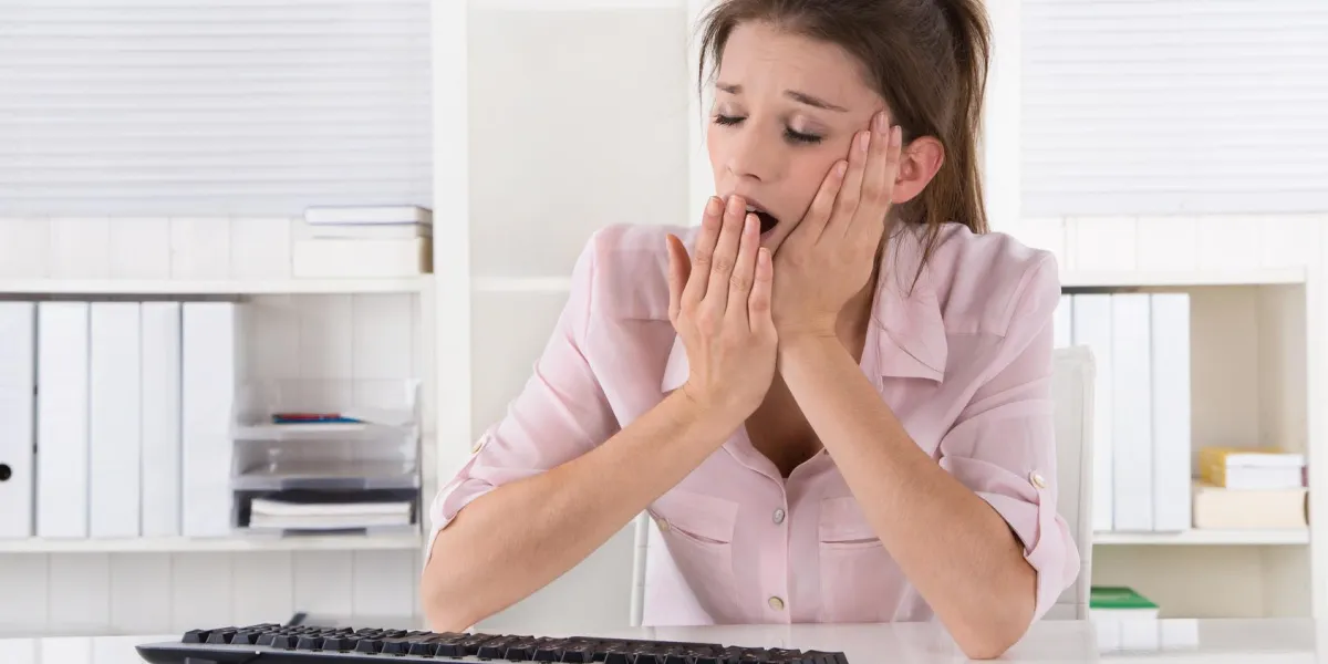 jeune femme s'assied baillant et endormi au bureau