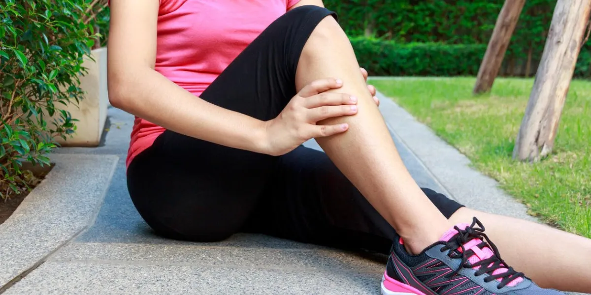 asian sporty woman leg pain or calf muscle while jogging or running
