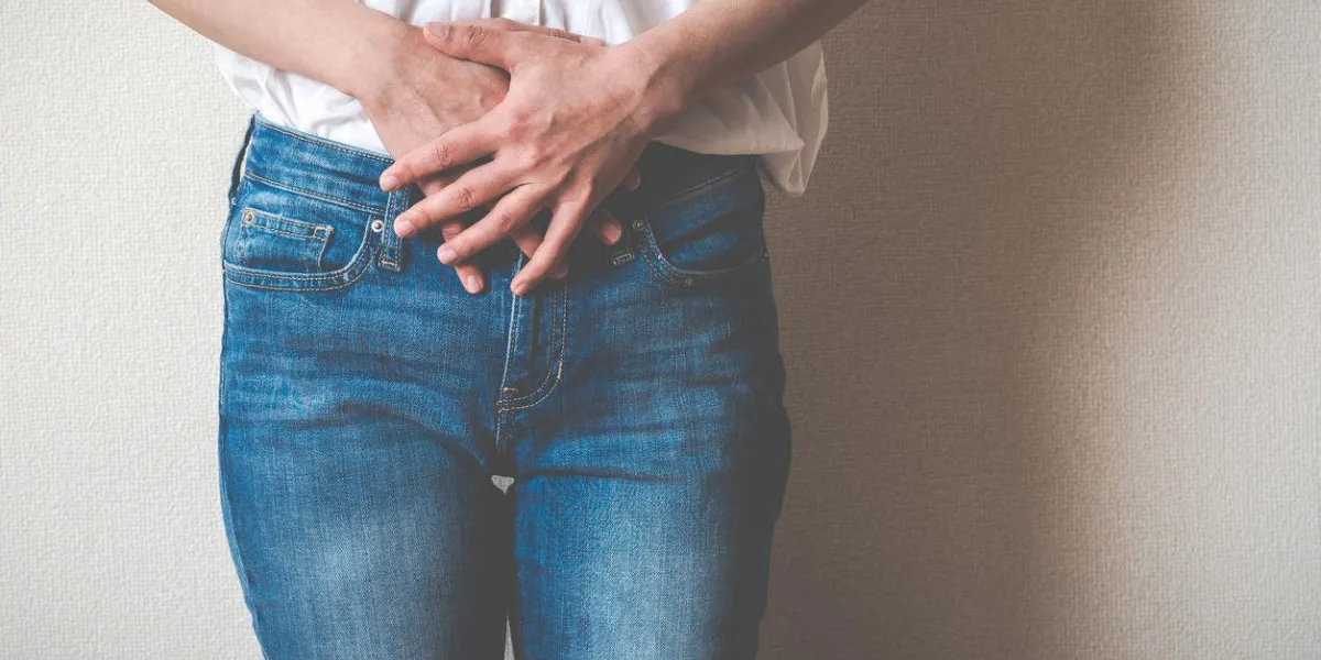 women touching lower abdomen