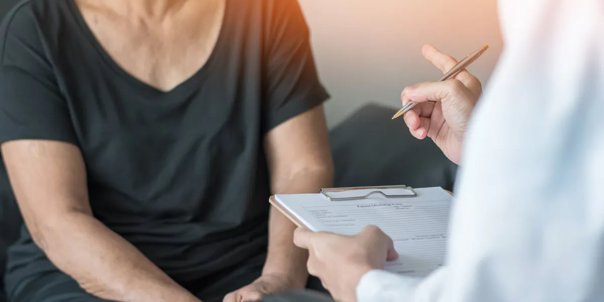 geriatric doctor (geriatrician) consulting and diagnostic examining elderly senior adult patient (older person) on aging and mental health care in medical clinic office or hospital examination room