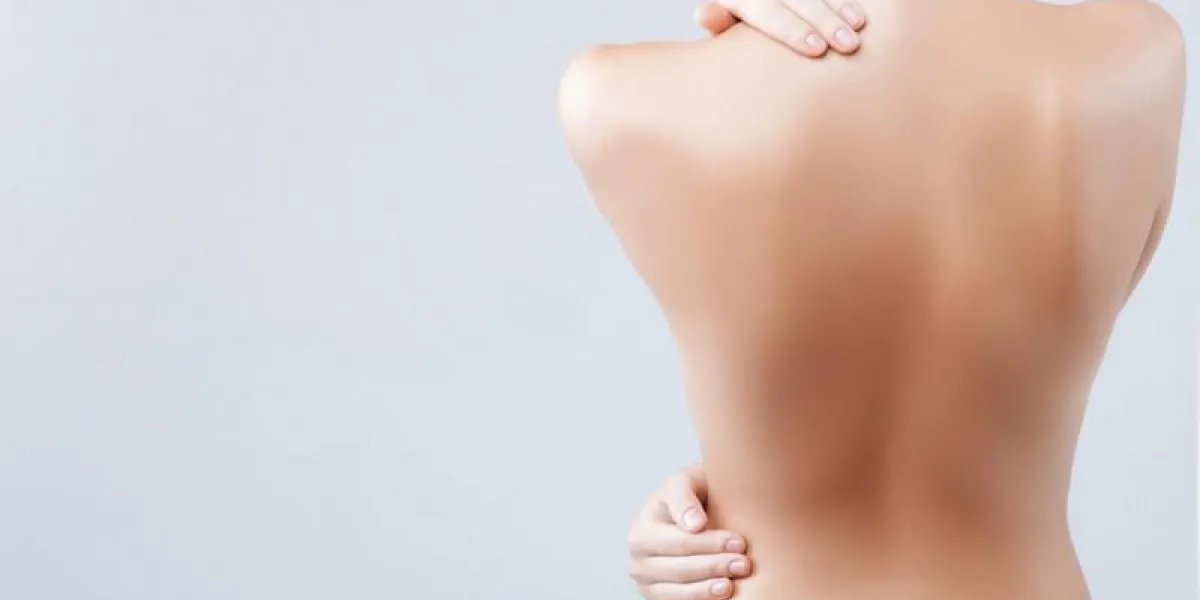 ma peau est lisse et douce près du dos nu féminin la fille est debout et touche son corps soigneusement isolé et copie espace dans le côté gauche