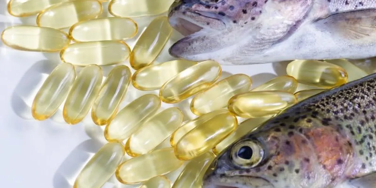 image de la truite, l'accent principal sur le second, et les pilules d'huile de poisson sur blanc