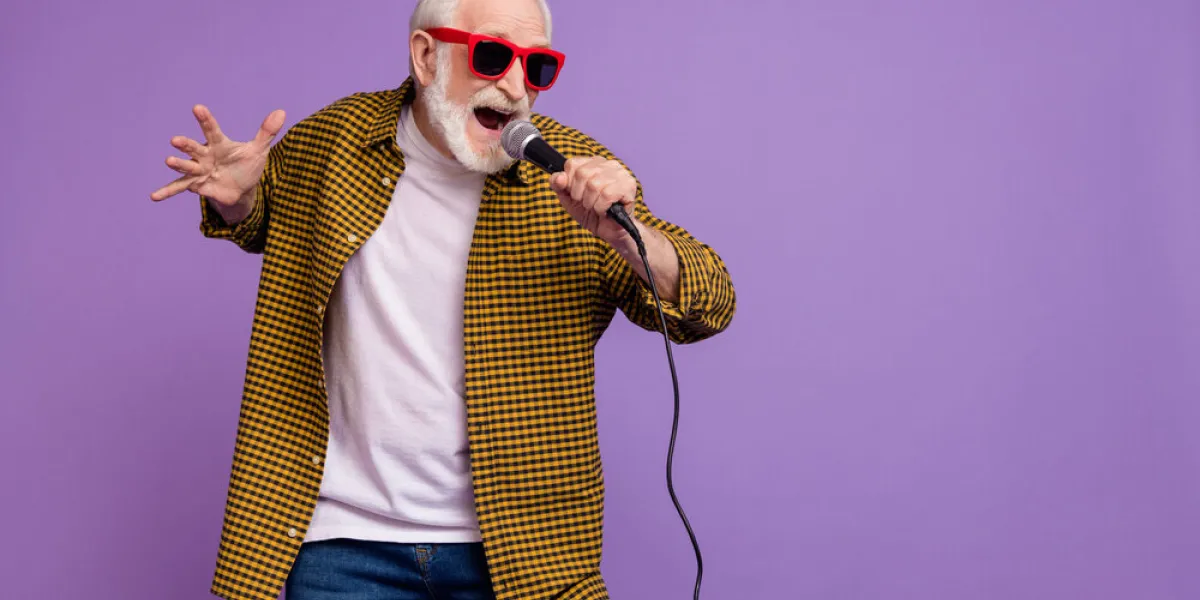 photo of handsome grandparent grey hair open mouth sing have fun wear trendy yellow plaid shirt isolated on lilac violet color background