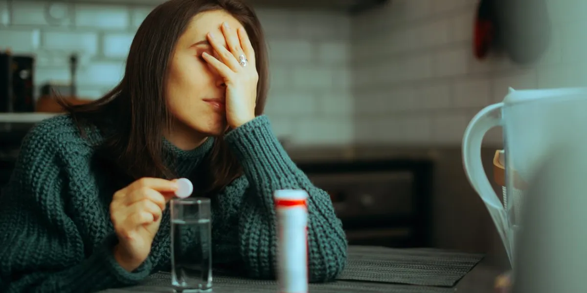 sick woman taking an effervescent multi vitamins pill