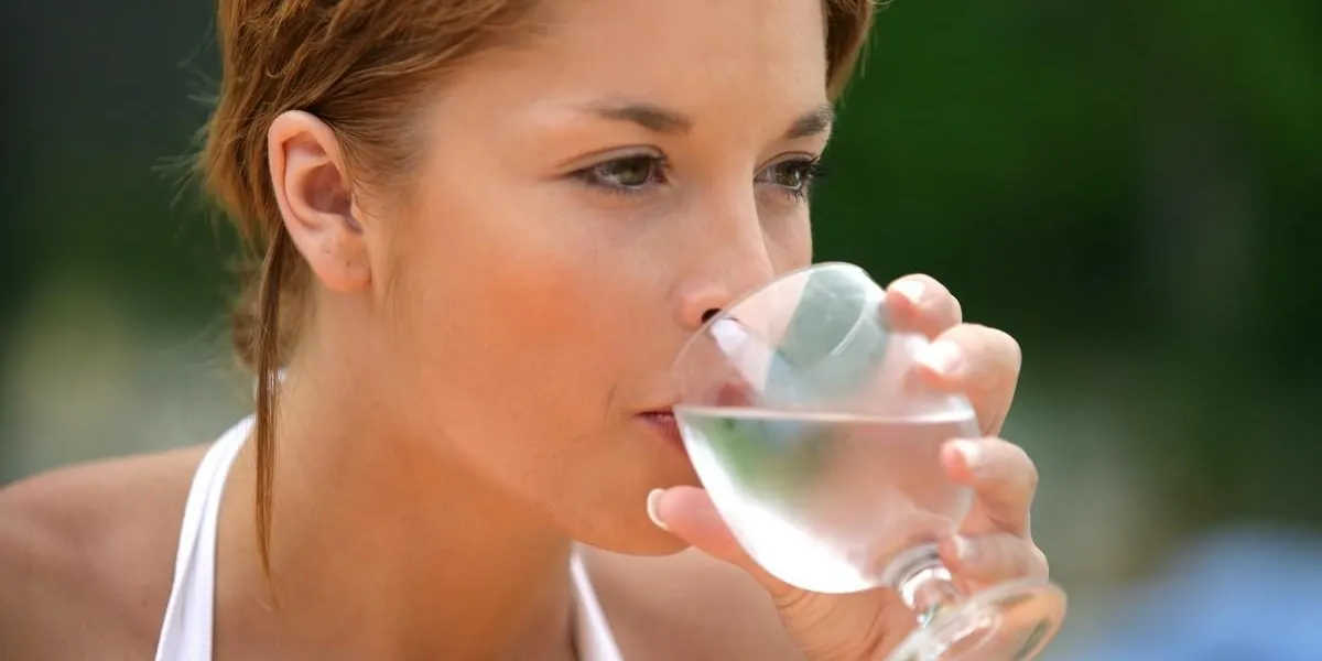 jeune femme buvant un verre d'eau