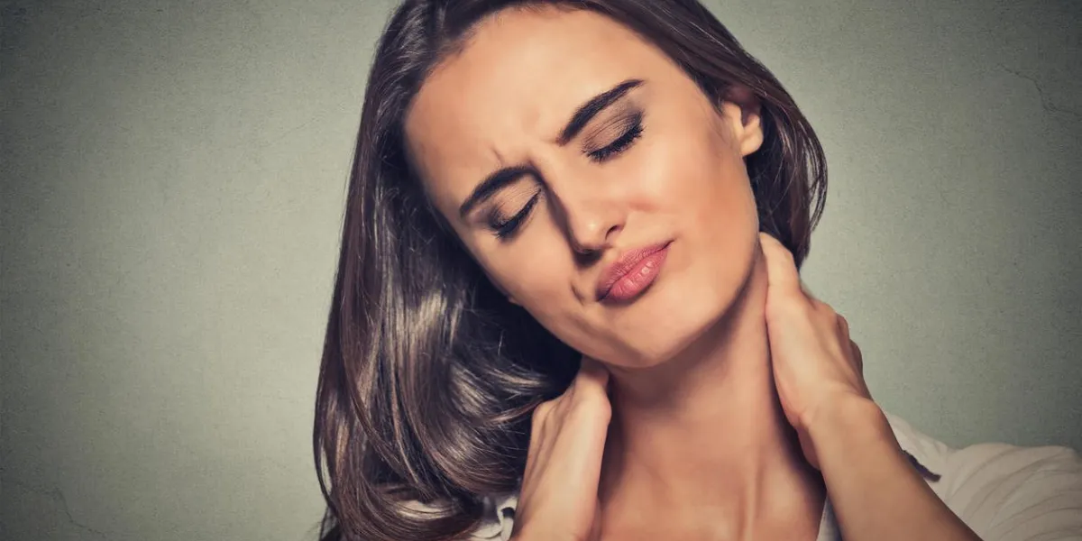 back and spine disease closeup portrait tired woman massaging her painful neck isolated on gray wall background face expression