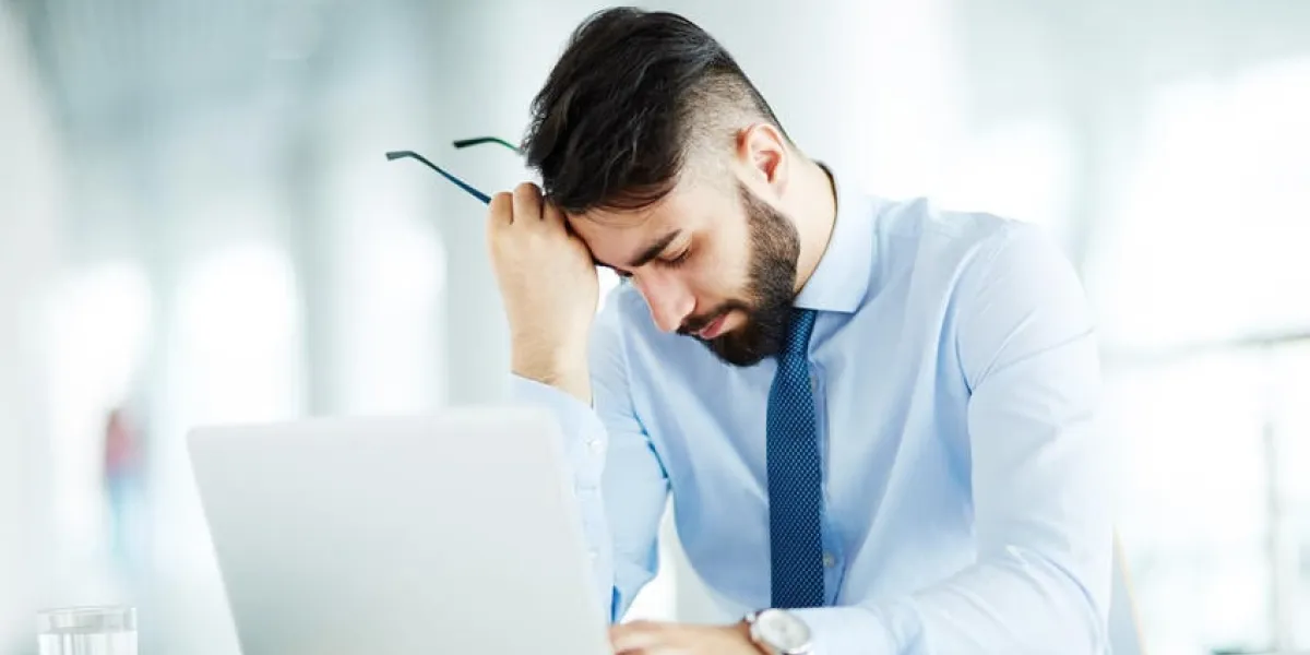 jeune homme d'affaires assis fatigué au portable