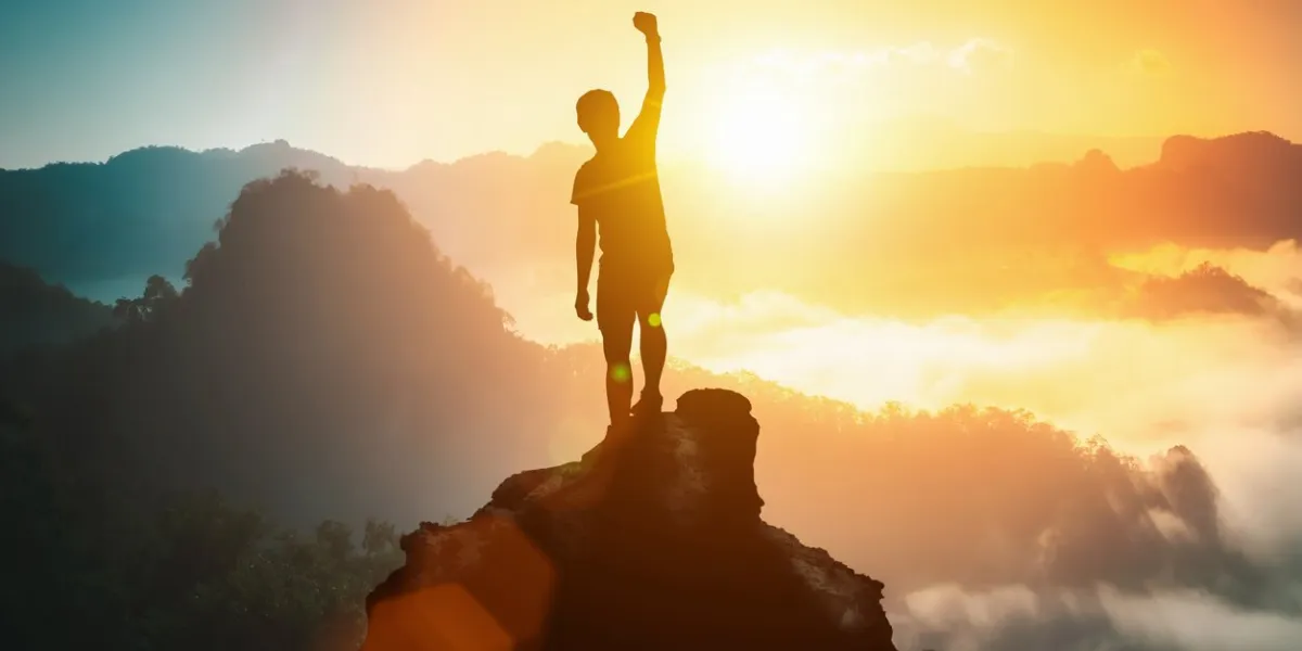 silhouette of positive man celebrating on mountain top, with arms raised up, silhouette of man standing on the hill, business, success,victory,leadership,achievement concept freedom travel adventure