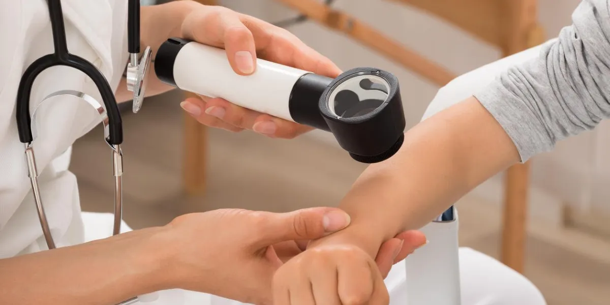 close-up of doctor examining skin of child patient with dermatoscope
