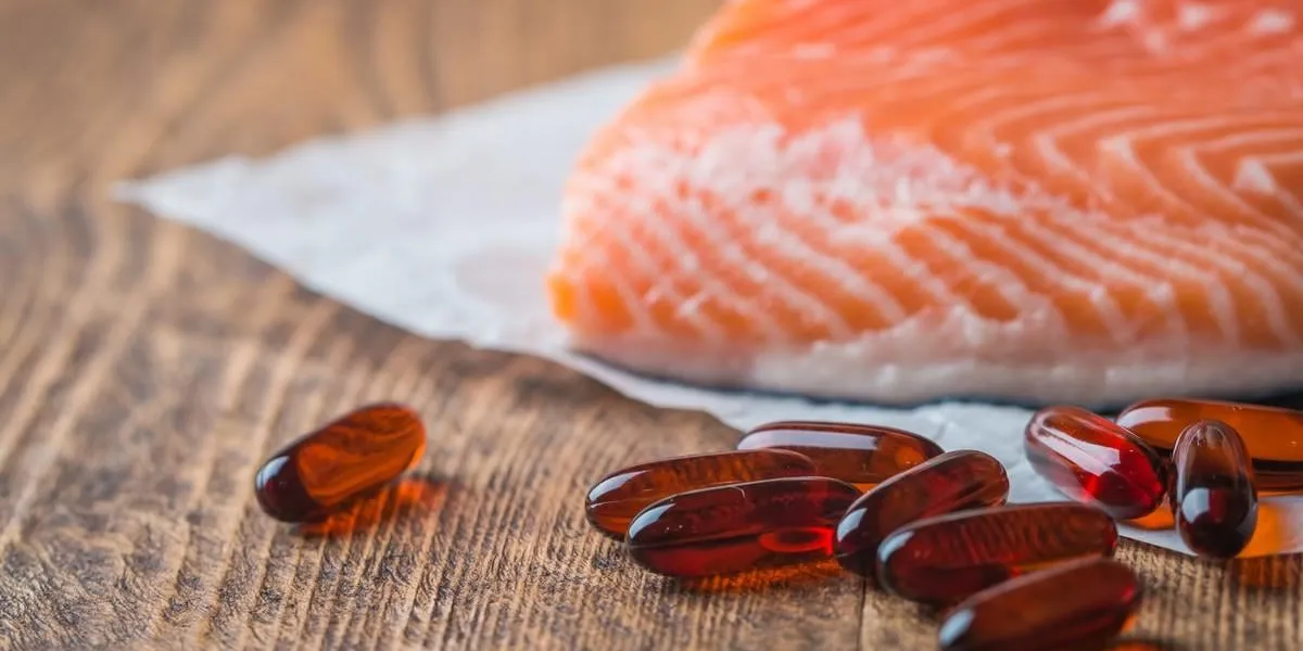 fish oil capsules with omega 3 on wooden background, healthy diet concept, close up