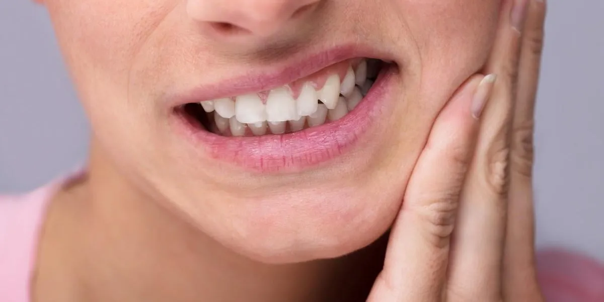 close-up of young woman suffering from toothache at home