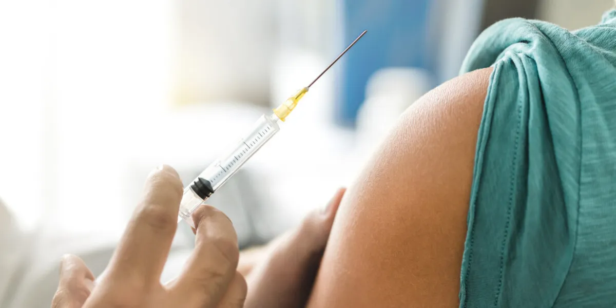 vaccine or flu shot in injection needle doctor working with patient's arm physician or nurse giving vaccination and immunity to virus, influenza or hpv with syringe appointment with medical expert