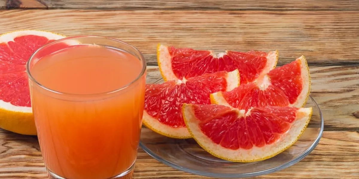 pamplemousse mûr avec du jus sur un close-up de table en bois