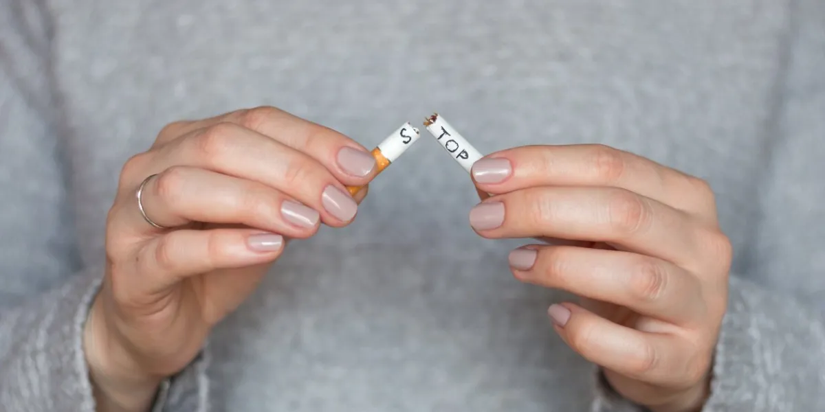 stop smoking cigarettes concept girl breaks a cigarette with the words stop