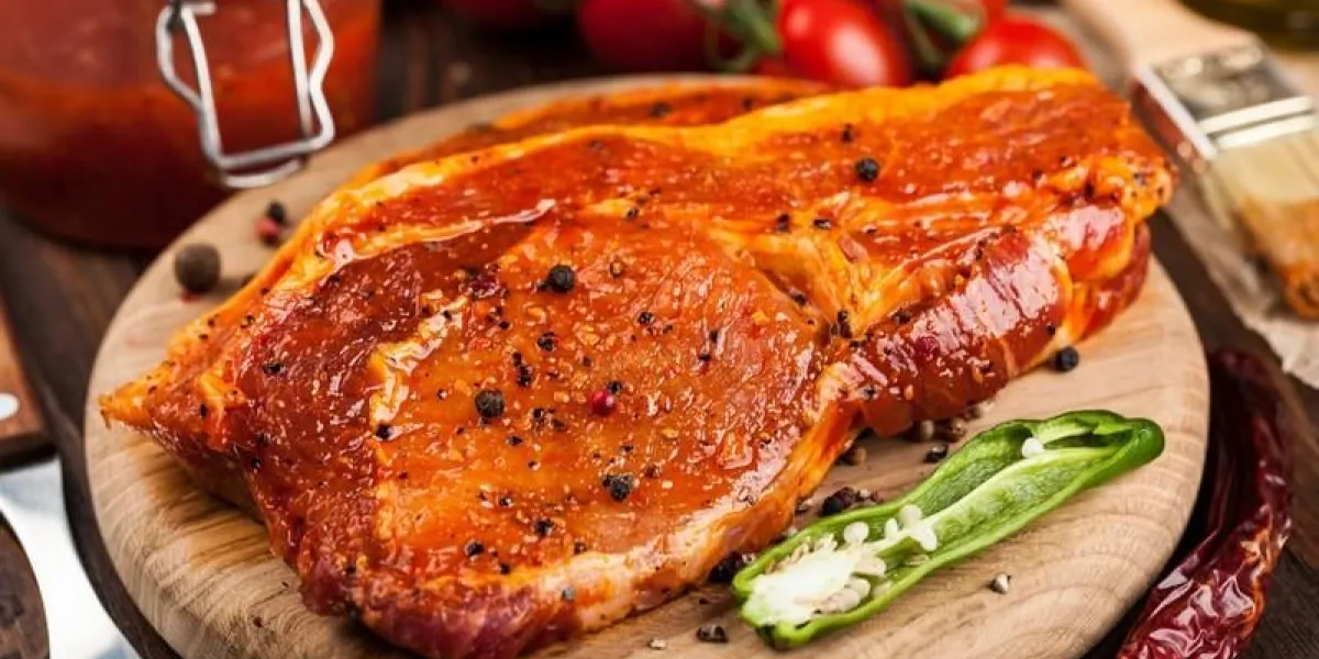 marinated pork steaks on cutting board and ingredients for cooking