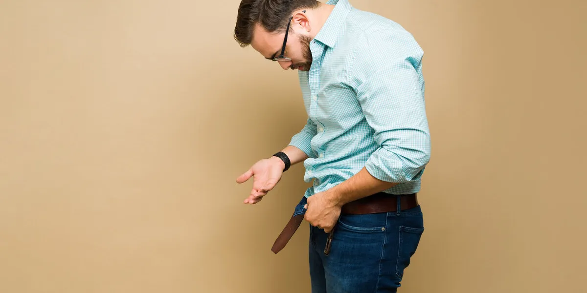 stressed sad man looking down to his erection and suffering from impotence or erectile dysfunction