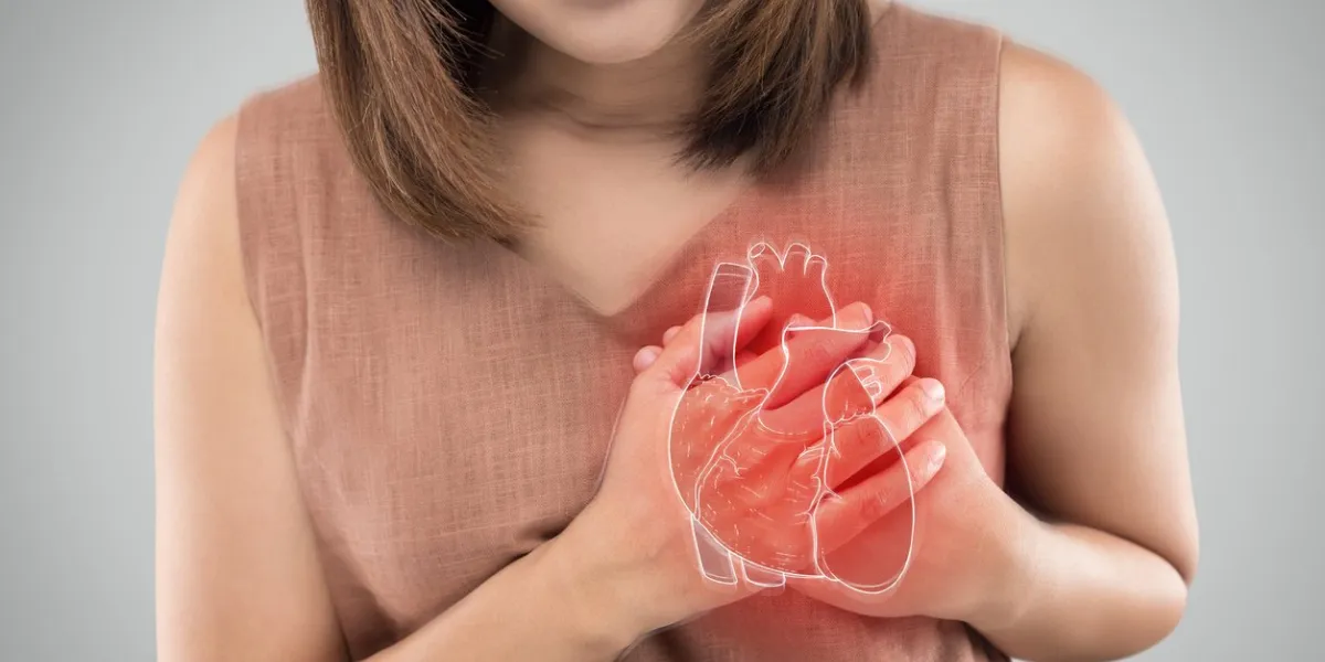 the photo of heart is on the woman's body, severe heartache, having heart attack or painful cramps, heart disease, pressing on chest with painful expression