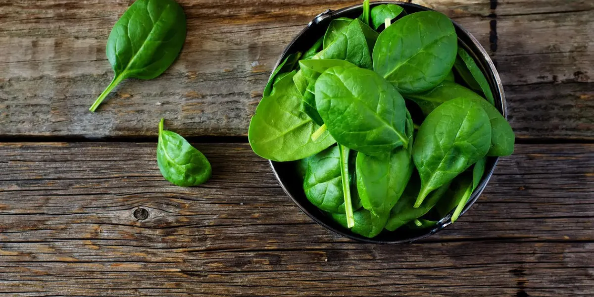 épinards dans le bol sur le fond de bois sombre tonification mise au point sélective sur la feuille inférieure droite