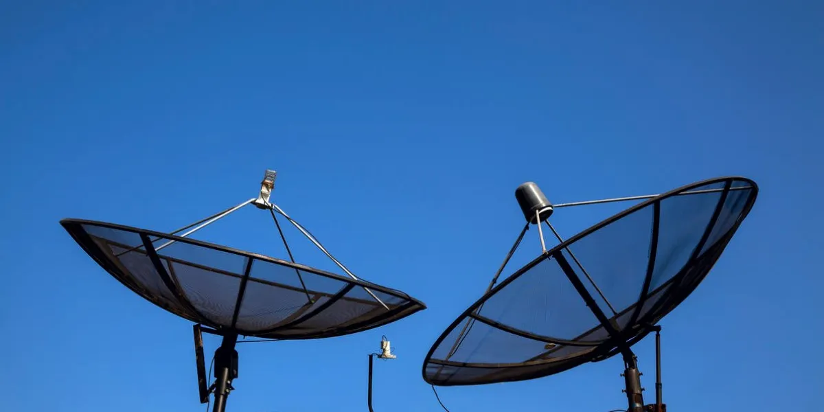 parabolic satellite antenna on blue sky background