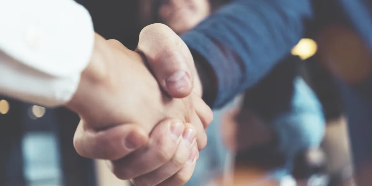 business people shaking hands in the office after succesful meeting three persons