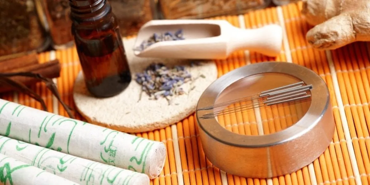 acupuncture needles, moxa sticks, lavender petals with macerated oil, giner and herbs in jars tcm traditional chinese medicine concept photo