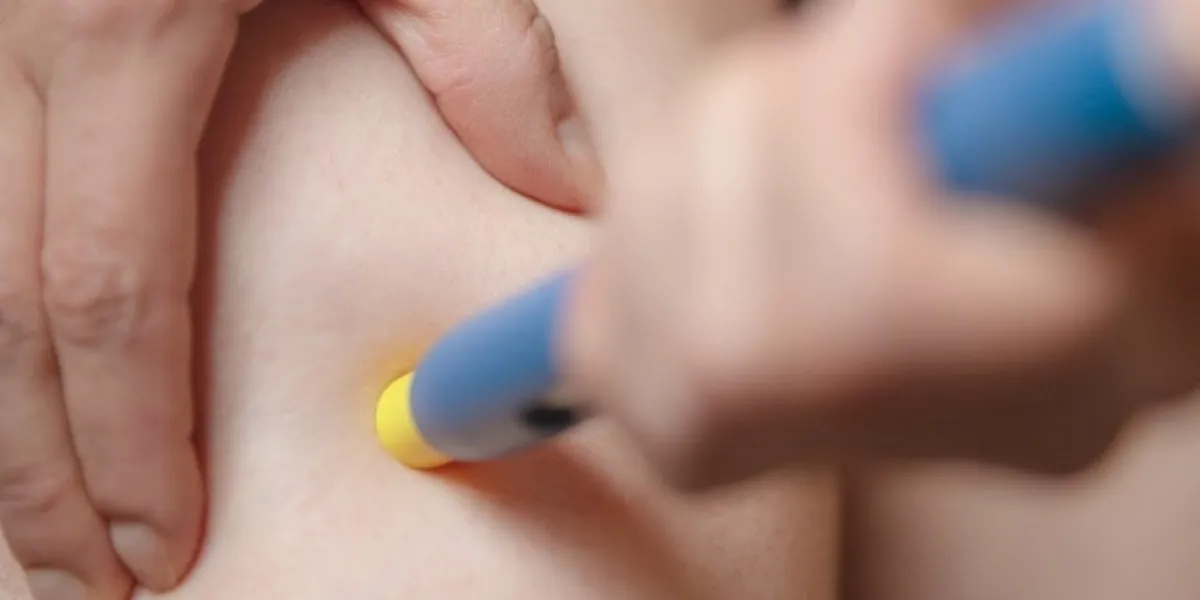 woman using a pre-filled syringe or pen injection into the femoral area, closeup, herself medical shot, injector for diabetes or allergy