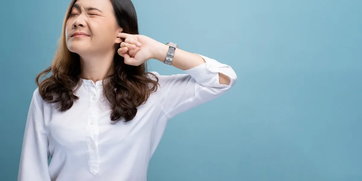 woman putting a finger into her ear