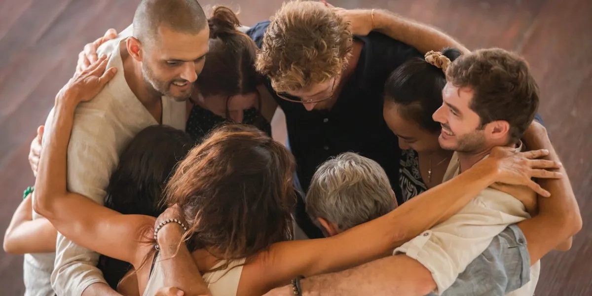 diverse group of multiethnic people embracing and giving hugs to each other staying in circle support, friendship and people connection concept