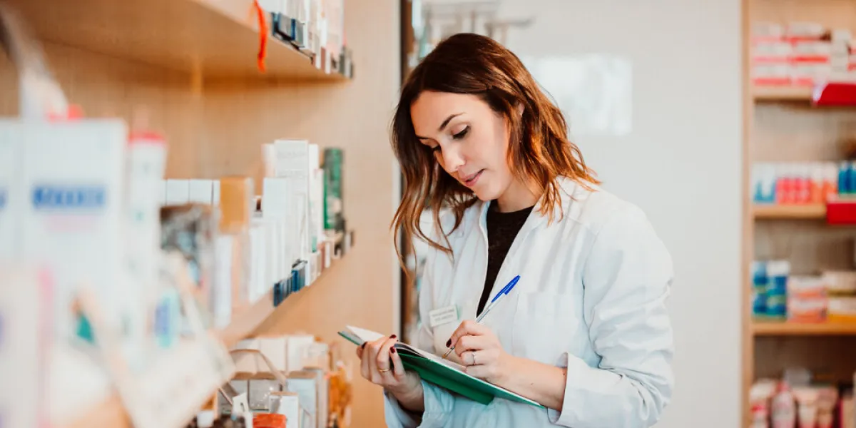 young female pharmacist working in her large pharmacy placing medications, taking inventory lifestyle