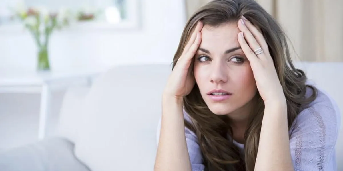 femme malade souffrant de maux de tête à la maison dans le salon