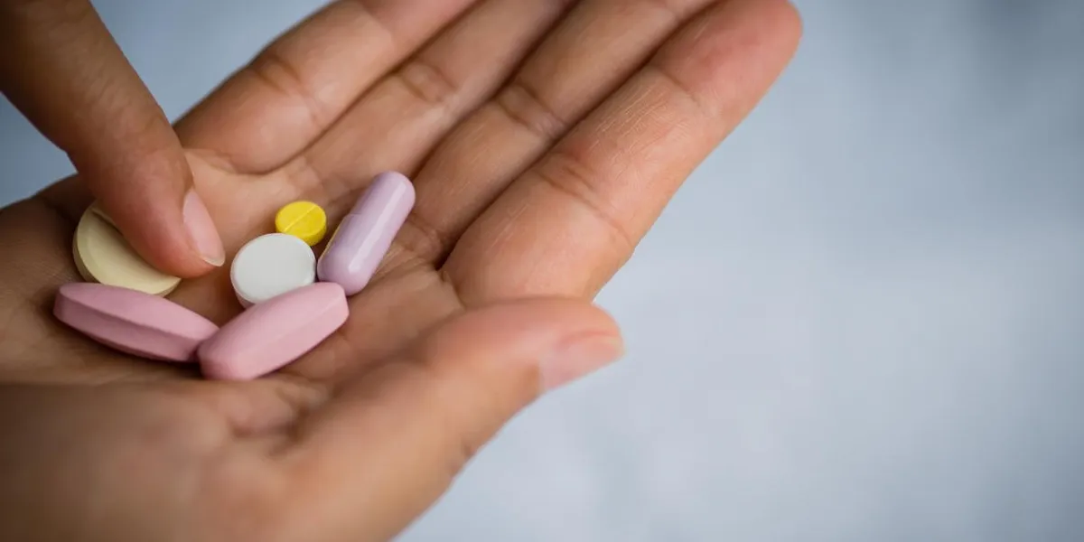 closeup woman hand holding a pill healthcare, medical supplements concept