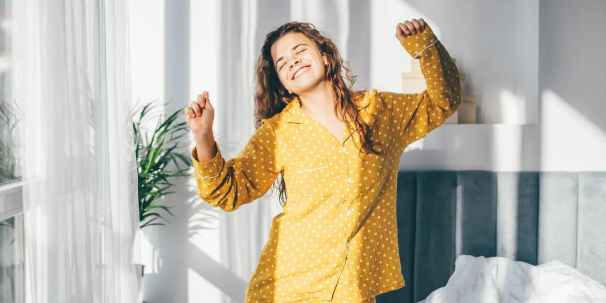 woman in yellow pyjamas dancing in morning at home